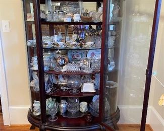 Antique Bowed Front China cabinet filled with crystal, glass dishes, candlesticks...