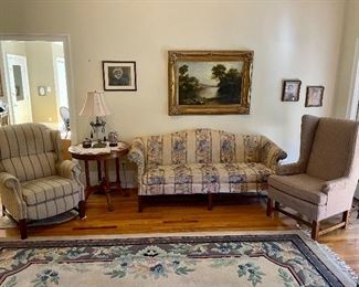 Chippendale sofa, striped recliner, Wingback/Straight-back chair, Round Oak Clawfoot table, Capel 9x12 Cut Pattern rug, gold framed oil on canvas landscape picture  