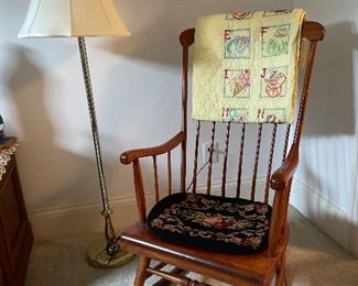 floor lamp and maple rocker, baby quilt.