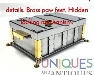 Lot 34 Steel and Brass Box. Strap details. Brass paw feet. Hidden locking mechanism.