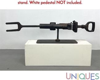 Lot 157 Industrial art sculpture. Jack Hammer on steel stand. White pedestal NOT included.