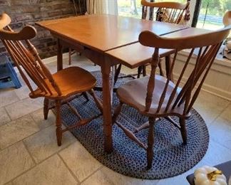 Wooden table both ends extend out has three chairs