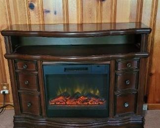 Electric fireplace also tv stand has drawers to hold dvds.