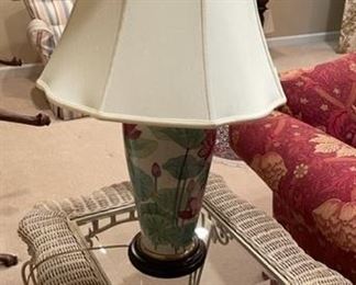 White wicker and glass end table with ceramic lamp.