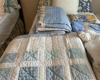 Assorted quilts and bedding.