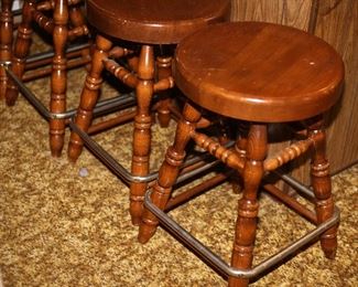 Four Vintage Solid Wood Swival Bar Stools with Metal Foot Rests.