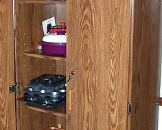 Storage cabinet with small kitchen appliances and cookware