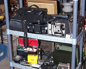 Assorted cameras and equipment, movie cameras, projectors with names such as Nikon, Kodak, Polaroid, etc...