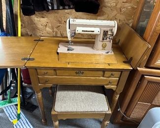 Singer sewing machine in cabinet w/bench.