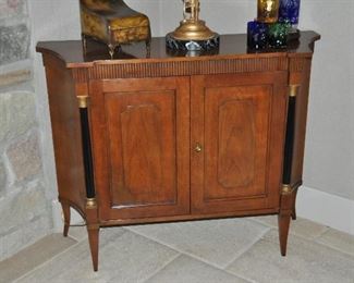 Baker Furniture Company Regency Style Two-Door Walnut Cabinet with Ebonized Columns and Gilt. Three interior shelves for storage. W43" x H34" x D14"