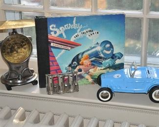 Displayed are a Vintage Salter's Scale 11# Scale No.225; Sparky the Talking Train Record Set, 75rpm; a Vintage Coin Changer; and a Vintage Buddy L Car