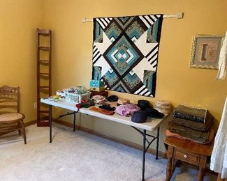 Quilted wall hanging, vintage hats, stack of wool blankets