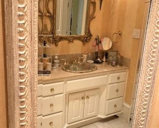 Rectangular mirror reflecting another beautiful bathroom.