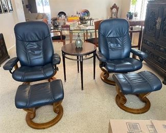 Pair of leather Eames style chairs with ottomans.