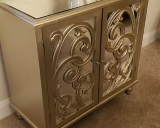 Mirror scrolled cabinet with shelf.