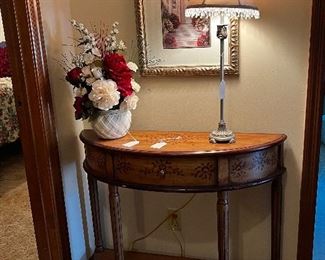 Hallway demilune table, lamp and framed pictures