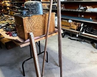 Vintage survey equipment. Tripod, transit and measuring stick.