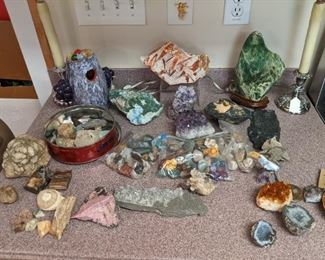 Crystals, geodes, polished stones, petrified wood, fossils and brain coral.                                                                                     The purple bird nest pottery, far left rear, is by the late GA folk artist Larry Wilson. There's a collection of five of his pieces in this sale.