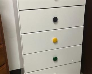 5 drawer dresser with colorful knobs.