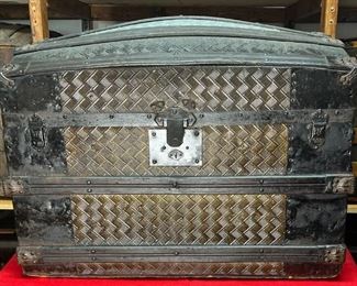 1880's Camel Back Featuring Cast Iron Hardware
This trunk would be considered a Camel Back trunk that has cast iron hardware with a patent date of October 23rd 1877. It has a common flat key lock and metal latches. The stamped tin was patented and introduced in the 1880s. 

*Please note we can ship this item although it is marked pickup only, just know there will be additional costs.

31L x 19D x 24