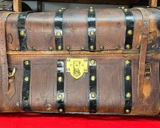 1800's Kidney Trunk
This trunk is considered to be a Kidney trunk because of its shape. Some might also call it a 6 Ban Jenny Lind for the same reason with all brass buttons. A beautiful, stamped saddle leather with a Star lock from Star Lock Works in Philadelphia. They made a variety of nice brass trunk locks for trunk makers. They didn't actually make the trunks, but they made really nice trunk locks. They were founded in 1836 by Mr. Liebrich and originally the locks were marked with C. Liebrich, Phila. Then in 1869, he retired and two partners, Hillebrand and Wolf took over the company and called it Star Lock Works. They made trunk locks and stays, keys, padlocks, latches and springs." This trunk has all its colorful insides which makes it even more valuable. 

*Please note we can ship this item although it is marked pickup only, just know there will be additional costs.

31L x 20D x 20H