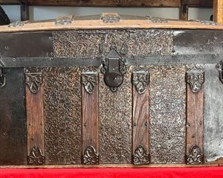 1870's Medium Camel Back Featuring Wooden Handles
This is a medium Camel back trunk with wooden handles. You will not find these on a regular or oversized trunk because the wood would not be strong enough. It has a nice lock and Taylor Bolts. The stamped tin was patented in 1877. A very nice trunk to refinish for your showroom or at the end of your bed for storage.

*Please note we can ship this item although it is marked pickup only, just know there will be additional costs.

30L x 15D x 17H