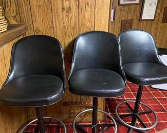 Three black swivel bar stools.