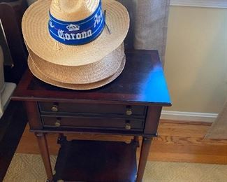 End table and straw hats.