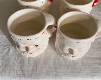 Four vintage Christmas ceramic Santa mugs.