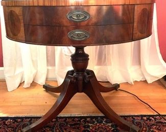 Round Leather Top Drum Table
This table has two drawers and six faux drawers, gold gilding, wheels, and brass feet. It is 34" in diameter and  29" high. 