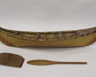 NW NATIVE OLD MODEL OF A ATHABASKAN BIRCH BARK CANOE. INCLUDES THE PADDLE AND FLOOR COVER. 17" LONG, 4.75" WIDE. IMBRICATION WEAVING ON EDGE. SPLIT AREAS ON ONE SIDE