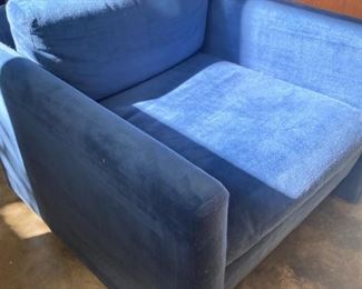 One of two matching upholstered blue modern chairs