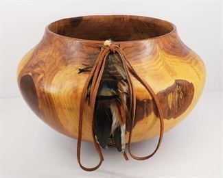 Entitled "Pueblo Magic". This wooden vessel was hand turned from a piece of red cedar wood by Robert J. Lentz of Chesapeake Wood Art, Pungoteague, Virginia. The artist has also incorporated leather lacing and feathers as decorative elements. With original COA and paperwork. 8" tall and 12" in diameter.