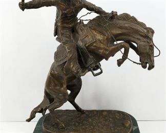 Late 20th century bronze sculpture from the original Frederic Remington bronze entitled "The Bronco Buster". On a green marble base. 8 3/4" tall (plus 3/4" base), 7" long, and 4" wide.