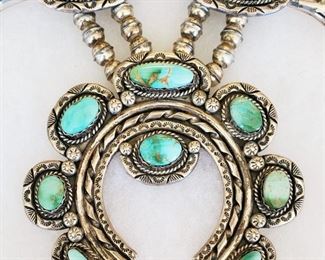 28" long Navajo turquoise and sterling silver squash blossom necklace, signed V&N (Vincent & Nita) Edsitty, and matching pierced earrings. The necklace contains 18 stones. The naja is 3 1/2" wide and 3" long. The earrings are 1" long and 1/2" wide. The turquoise appears to be Royston, but please make up your own mind after reviewing the photos.