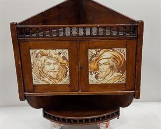 NTIQUE WALL MOUNT ENGLISH CORNER CABINET. FITTED WITH RAILS, LEVER LOCK AND TWO PORTRAIT TILES BY MINTON HOLLINS & CO. 32.5" TALL. 