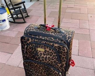 Leopard rolling suitcase showing some external wear
