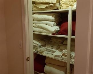 Packed linen closet blankets sheets pillows shams