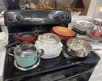 An assortment of cooking pots and pans including Le Creuset and Corning ware 