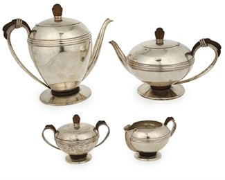 1031
A William Spratling Sterling Silver Tea And Coffee Service
William Spratling (1900-1967)
Circa 1945-1946, First Design Period; Taxco, Mexico
Stamped for William Spratling and sterling
Each with carved rosewood accents and a wrapped silver wire design, comprising a coffee pot (9" H x 10" W x 5.75" D), a tea pot (6.5" H x 10.5" W x 6.25" D), a creamer (2.25" H x 5.25" W x 4" D), and a covered sugar bowl (4.25" H x 5.75" W x 4" D), 4 pieces

79.115 gross oz. troy approximately
Estimate: $1,500 - $2,500