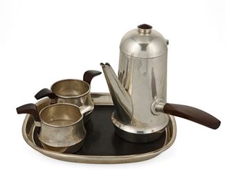 1032
A William Spratling "Voltero" Sterling Silver Tea Service
William Spratling (1900-1967)
Circa 1951-1967, Third Design Period; Taxco, Mexico
Each stamped for William Spratling and sterling; Further stamped: [Eagle 30]
Each with rosewood handles, comprising a chocolate/bachelors coffee pot (6.25" H x 7" W x 2.5" D), a creamer (2.625" H x 4.25" W x 3" D), and a sugar (2.125" H x 5" W x 2.375" D), together with an an ebony bottomed tray (0.875" H x 7" W x 8.75" L), 4 pieces

37.445 gross oz. troy approximately
Estimate: $1,000 - $2,000