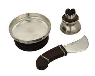 1033
A Group Of William Spratling Sterling Silver Table Items
William Spratling (1900-1967)
Circa 1931-1946, First Design Period; Taxco, Mexico
Each stamped for William Spratling and sterling
Comprising a cheese knife with rosewood handle (6.5" L x 0.625" W), a bowl with stars and a rosewood base (1.875" H x 4.125" Dia.), and a small candlestick with an engraved floral motif (2.375" H x 2.25" Dia.), 3 pieces

15.885 gross oz. troy approximately
Estimate: $400 - $600