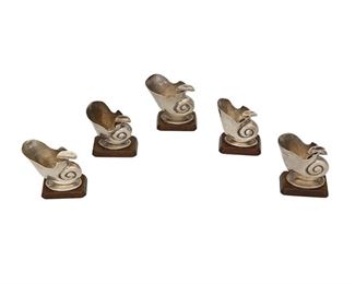 1036
A Group Of William Spratling Conch Shell-Form Ashtrays
William Spratling (1900-1967)
Circa 1940-1944, First Design Period; Taxco, Mexico
Each stamped for William Spratling; Further stamped: Spratling Silver
Each repousse ashtray in the form of a conch shell with cigarette rest, raised on a square rosewood base, 5 pieces

Each: 2.125" H x 2.25" W x 1.25" Dia.
8.325 gross oz. troy approximately
Estimate: $200 - $400