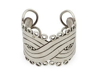 1049
A William Spratling Silver Cuff Bracelet
William Spratling (1900-1967)
Circa 1944-1946, First Design Period; Taxco, Mexico
Stamped for William Spratling; Further stamped: Made in Mexico / Sterling
A sterling cuff with Aztec-inspired design bordered with circular wire loops

6.5" total inner C x 2.25" H, including a 1" gap
151.9 grams
Estimate: $1,000 - $1,500