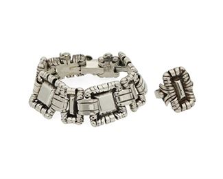 1059
A Set Of William Spratling Silver Jewelry
William Spratling (1900-1967)
Circa 1942 and 1944-1946, First Design Period; Taxco, Mexico
Each stamped for William Spratling; Variously marked: Made in Mexico / Spratling Silver
Comprising a sterling bracelet comprised of elaborate links of raised silver shapes edged with curled silver wire and a matching ring, 2 pieces

Bracelet: 7" L x 0.875" H; Ring size: 6.25
75.4 grams gross
Estimate: $800 - $1,200