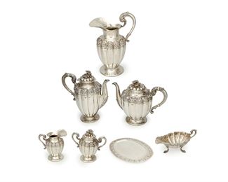 1130
A Mexican Sterling Silver Tea Service
Circa 1920-30s
Stamped: Alameda Plateria Juarez 58 / Sterling / Mexico
Comprising a water pitcher, tea pot, coffee pot, creamer, sugar, and sauce boat with underplate; all embellished with a floral motif and three-dimensional flower finials; both tea and coffee pot handles accented with banding of white stone, 7 pieces
Largest: 12.25" H x 7.75" W x 5" D; smallest: 2.875" H x 8.75" W x 4.25" D
Estimate: $2,000 - $3,000