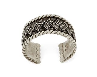 1179
A Hector Aguilar Sterling Silver Cuff Bracelet
Hector Aguilar (1905-1986)
Circa 1940-1945; Taxco, Mexico
Stamped: HA / Taxco / 940
A cuff with a heavy rope braid overlay within a border of flattened twisted wire, finished with ball terminals

6.75" total inner C x 1.25" H; including a 1" gap
119.7 grams
Estimate: $700 - $900