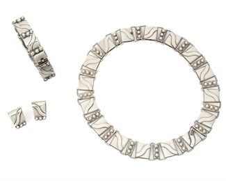 1180
A Set Of Hector Aguilar Sterling Silver Jewelry
Hector Aguilar (1905-1986)
Circa 1940-1945, 1953, and 1948-1962; Taxco, Mexico
Each stamped: HA / Taxco / 940; Variously stamped: Mexico / [Eagle 9]
Comprising a sterling triple-ball and wave-link "Lyre" necklace with a matching link bracelet and a pair of earrings, 3 pieces

Necklace: 16.25" L x 0.75" H; Bracelet: 7.375" L x 0.5" H; Each earring: 0.75" H
190.7 grams
Estimate: $800 - $1,200