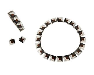 1242
A Suite Of Margot De Taxco "Shadow Box" Silver And Enamel Jewelry
Margot Van Voorhies (1896-1985)
Circa 1955-1978; Taxco, Mexico
Two stamped: Margot de Taxco / Sterling / Made in Mexico / [Eagle 16] / 5461; Earrings unmarked
Comprised of a link collar necklace with a matching link bracelet, each designed with square enamel links in black, white and brown, together with a pair of matching clip earrings, 4 pieces

Necklace: 15" L x 0.625" H; Bracelet: 6.5" L x 0.625" H; Each earring: 0.875" H
149.8 grams gross
Estimate: $600 - $800