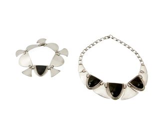 1260
A Set Of Fred Davis Silver And Obsidian Mask Jewelry
Fred Davis (1880-1961)
Pre-1948; Mexico City, Mexico
Each stamped for Fred Davis; Variously stamped: Made in Mexico / Silver
Comprising a carved obsidian mask and silver link necklace with a matching bracelet, 2 pieces

Necklace: 15" L x 1.5" H; Bracelet: 8" L x 1" H
106.7 grams gross
Estimate: $700 - $900